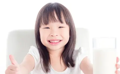牛乳コップ持った笑顔の子供