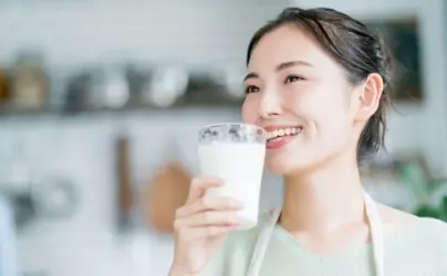 牛乳を飲む笑顔の女性